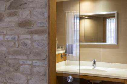 Cabine de douche moderne avec paroi en verre texturé et sol en galets.<br />