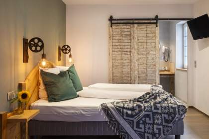 Chambre avec lits double et porte coulissante donnant sur la salle de bain